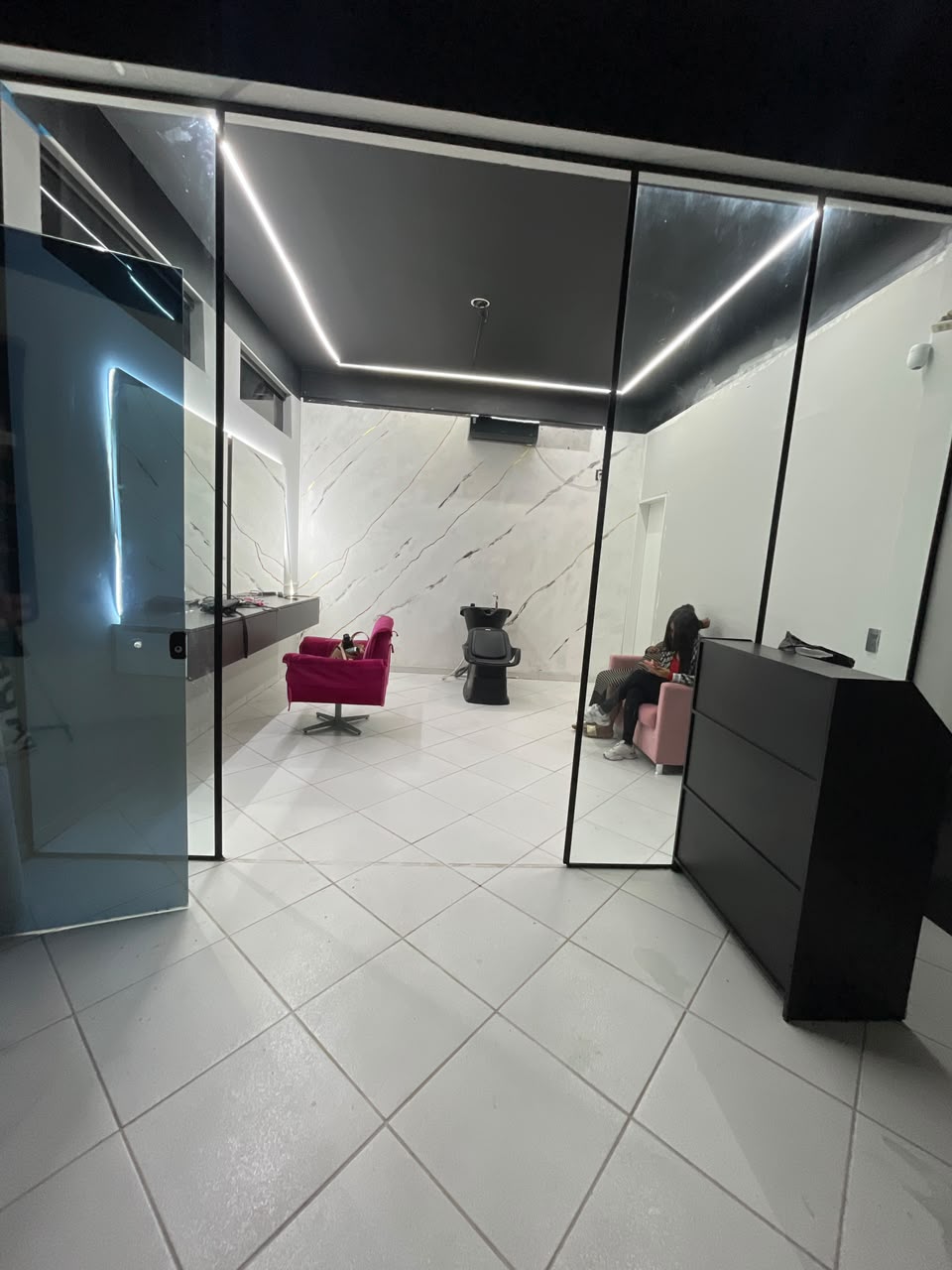 Interior do Studio Bruna Felix: recepção, poltronas rosé e parede em mármore